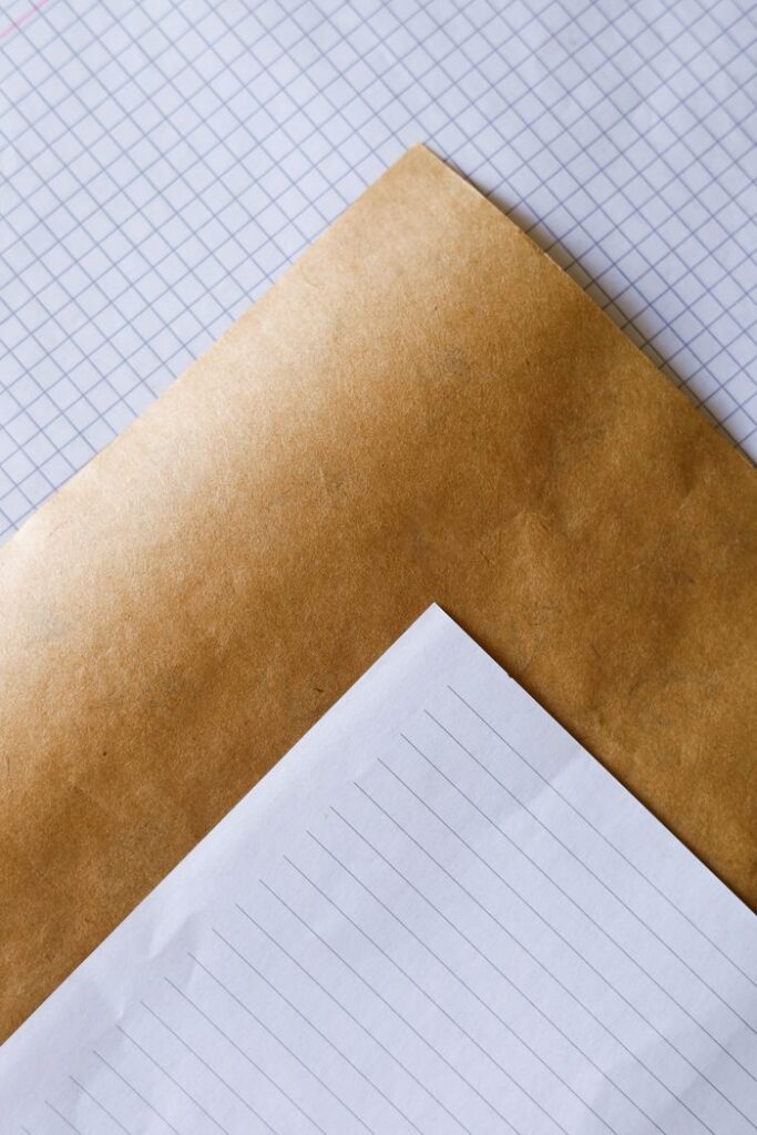 A close-up view of a stack of graph, lined, and kraft paper sheets arranged in a minimalist style.